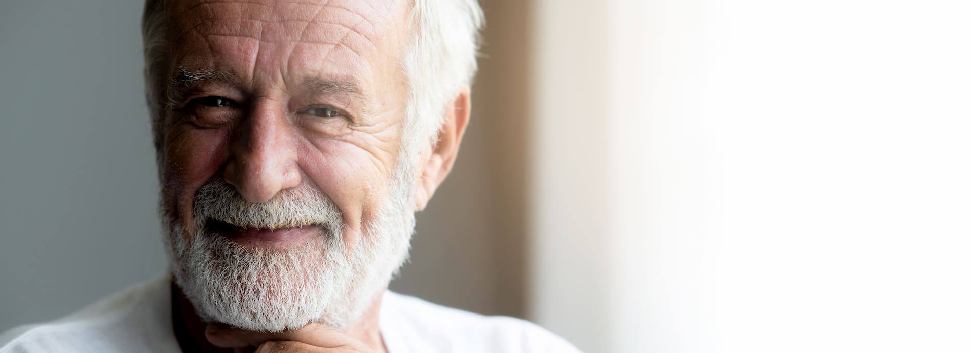 Happy senior man portrait. Bearded man. Wonderful smile. With light leaks. Banner frame.